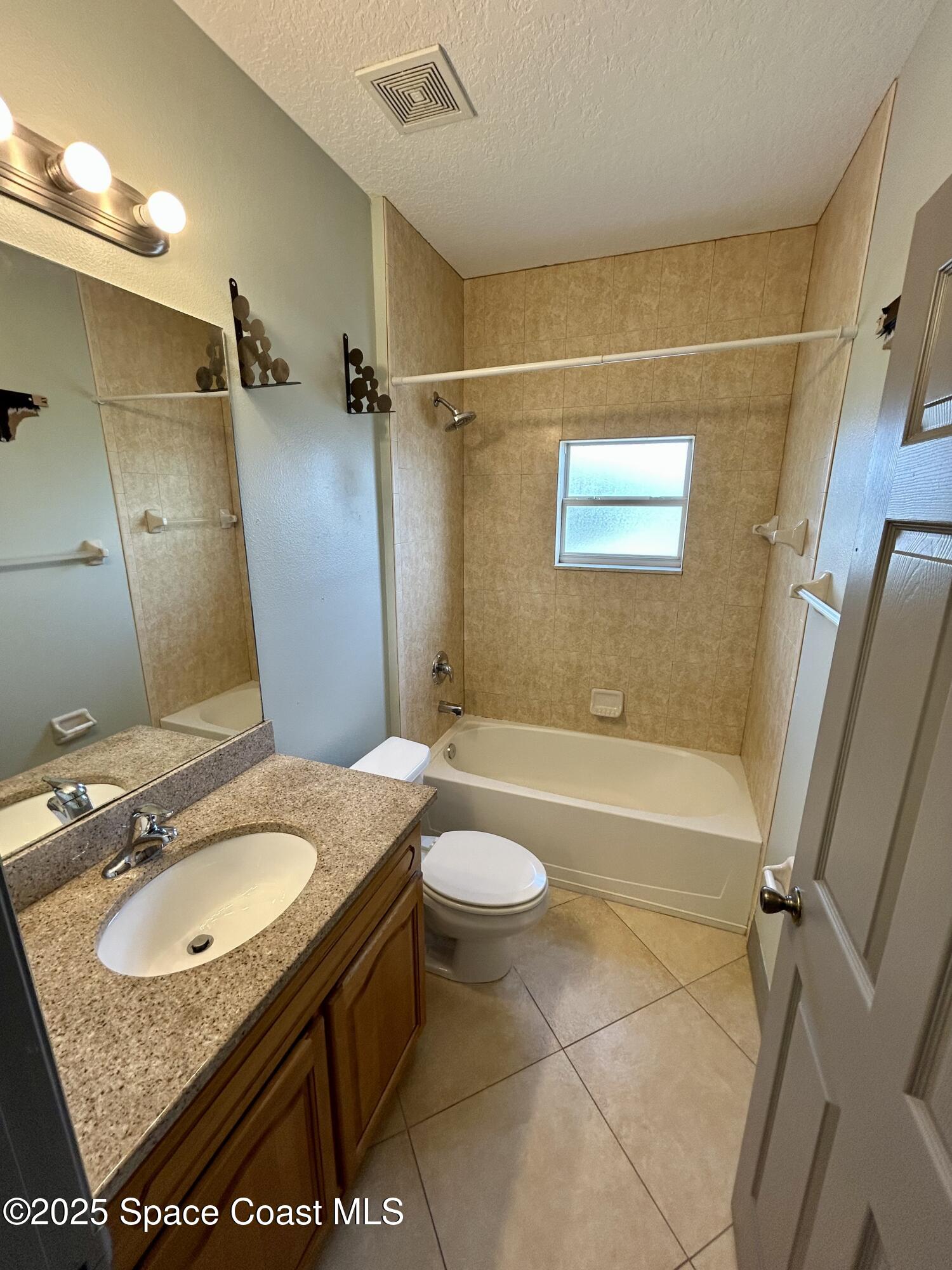 910 Twisting Branch Court Melbourne, FL 32935 - Photo 18 of 24 a bathroom with a granite countertop sink toilet and shower