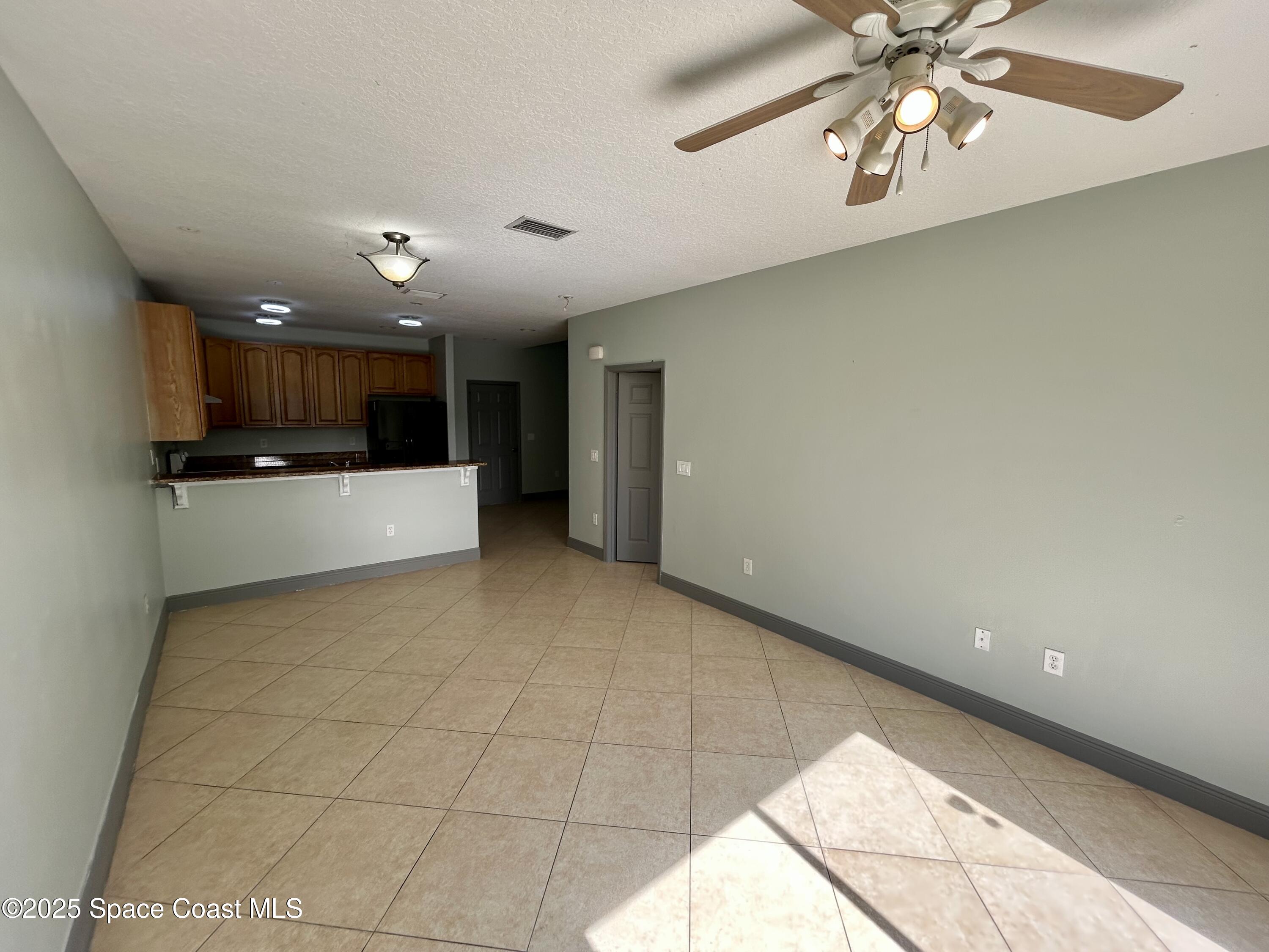 910 Twisting Branch Court Melbourne, FL 32935 - Photo 10 of 24 a view of a kitchen with a sink and a chandelier fan