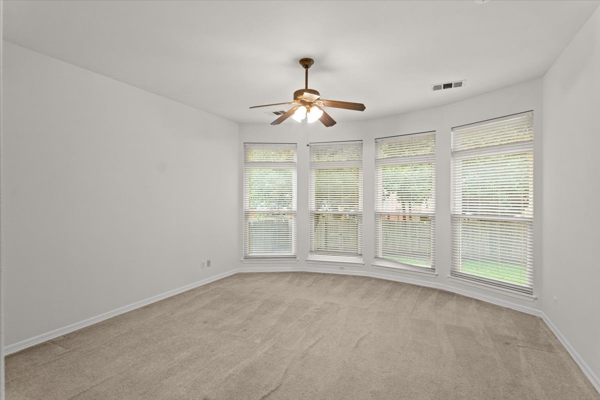 2304 Village View Loop Pflugerville, TX 78660 - Photo 24 of 40 A spacious room offers ample natural light and a practical ceiling fan.