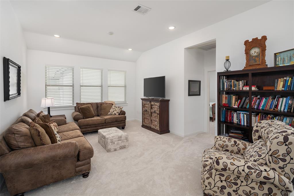 4881 Miles Way Fairview, TX 75069 - Photo 27 of 39 a living room with furniture a flat screen tv and a book shelf