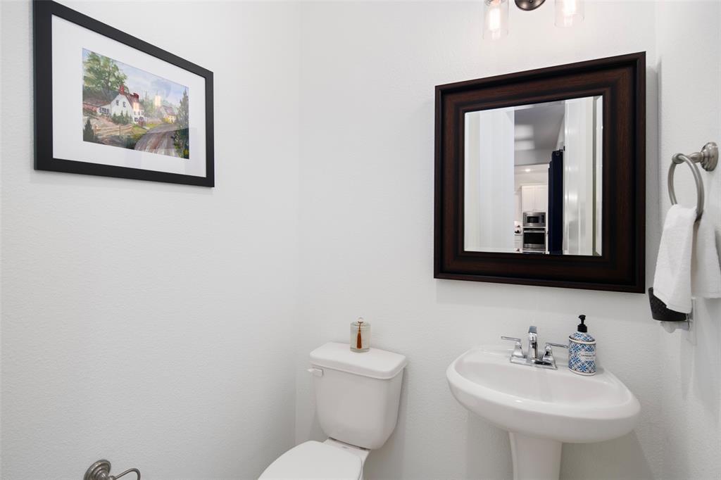4881 Miles Way Fairview, TX 75069 - Photo 32 of 39 a bathroom with a toilet a sink and mirror