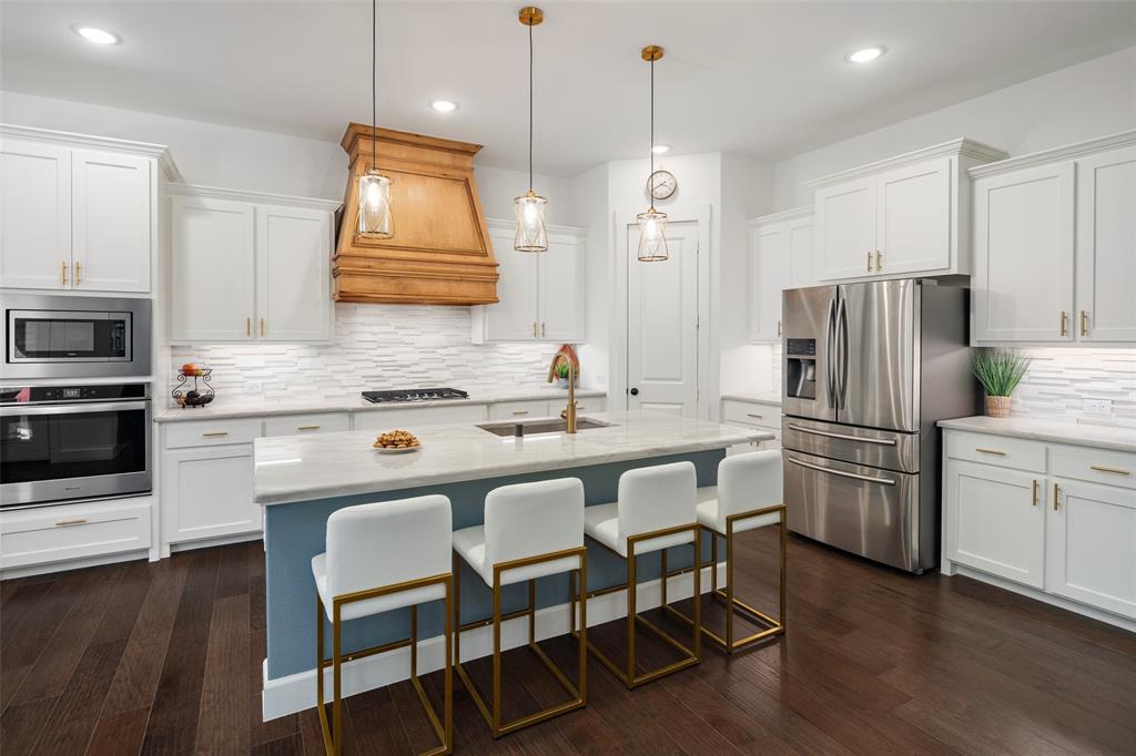 4881 Miles Way Fairview, TX 75069 - Photo 5 of 39 a kitchen with refrigerator a stove a sink and chairs