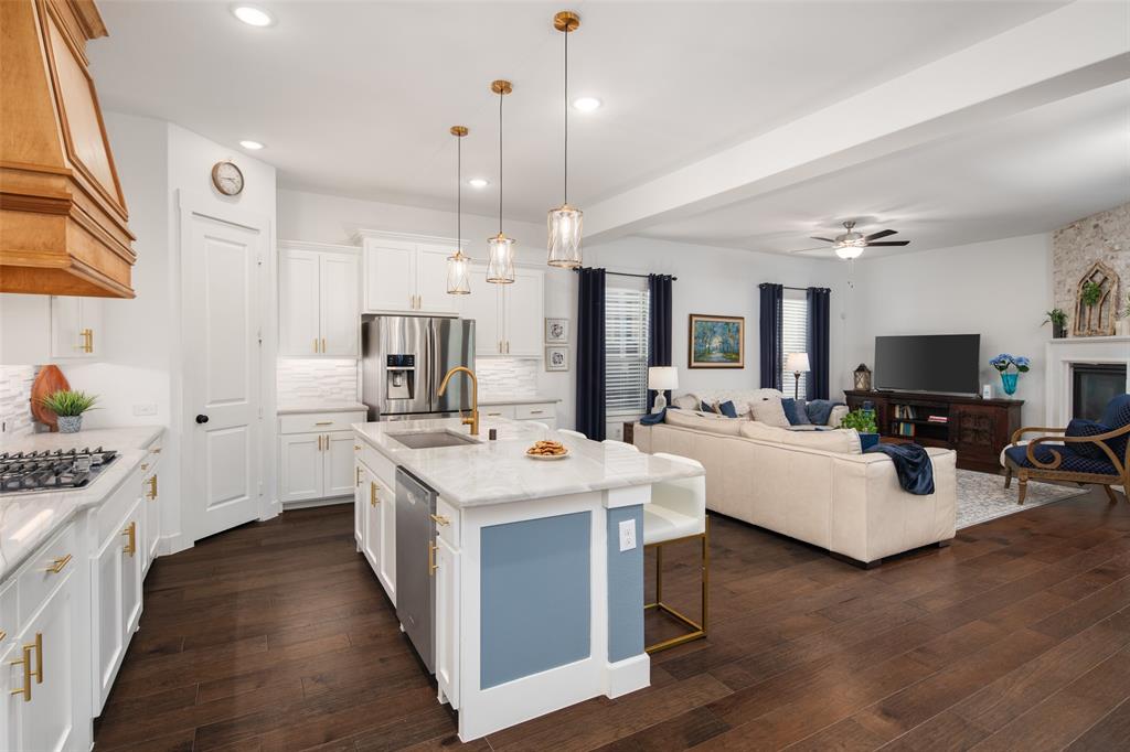 4881 Miles Way Fairview, TX 75069 - Photo 7 of 39 a large white kitchen with lots of counter space dining table and a couch
