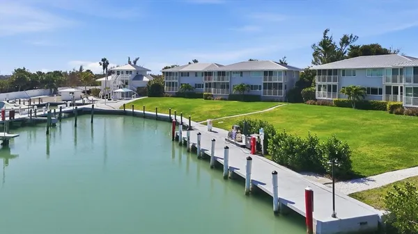 a view of a lake with a big yard and large trees