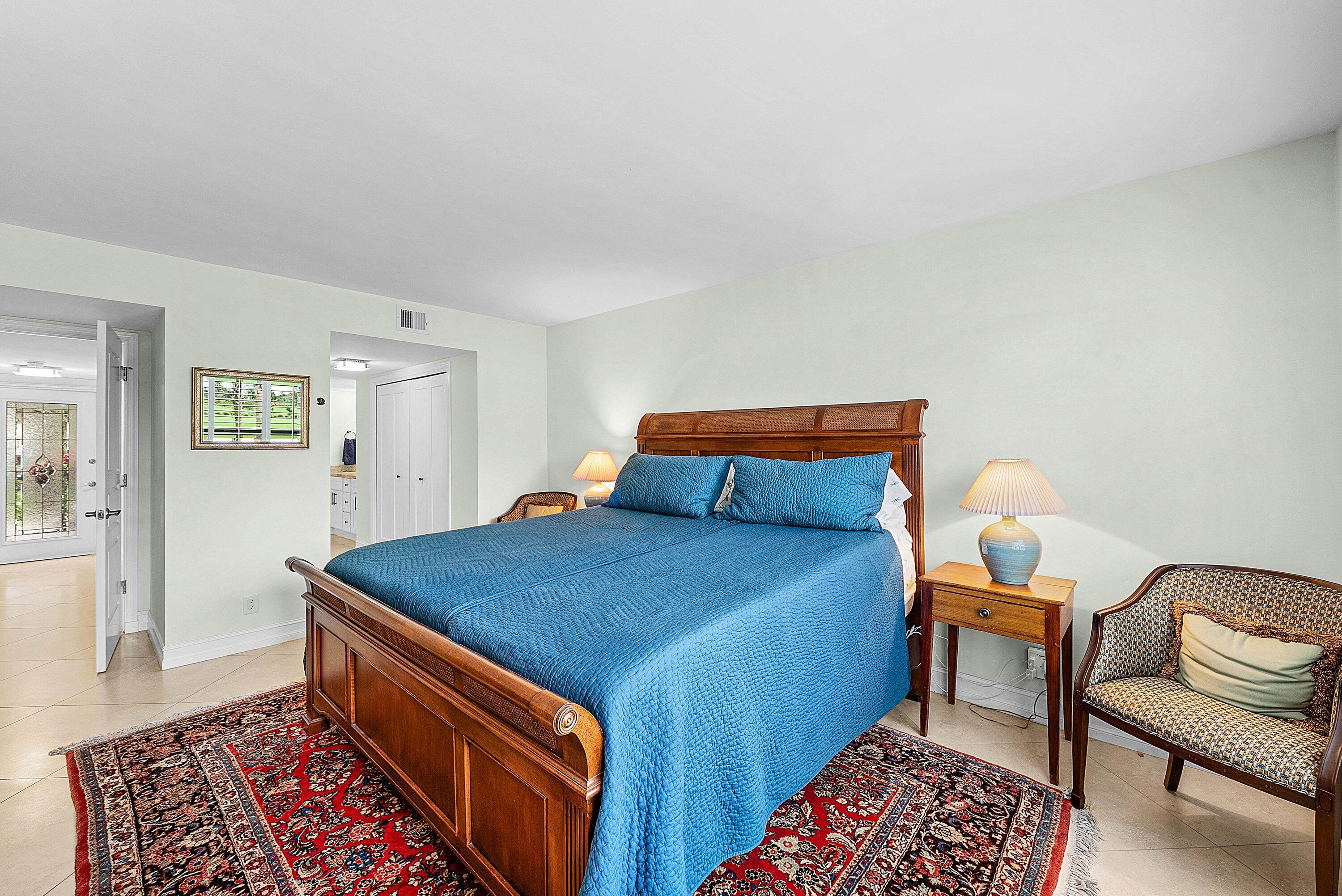 10171 Quail Covey Road, Unit HIBISCUS N Boynton Beach, FL 33436 - Photo 19 of 50 a bedroom with a bed and wooden floor