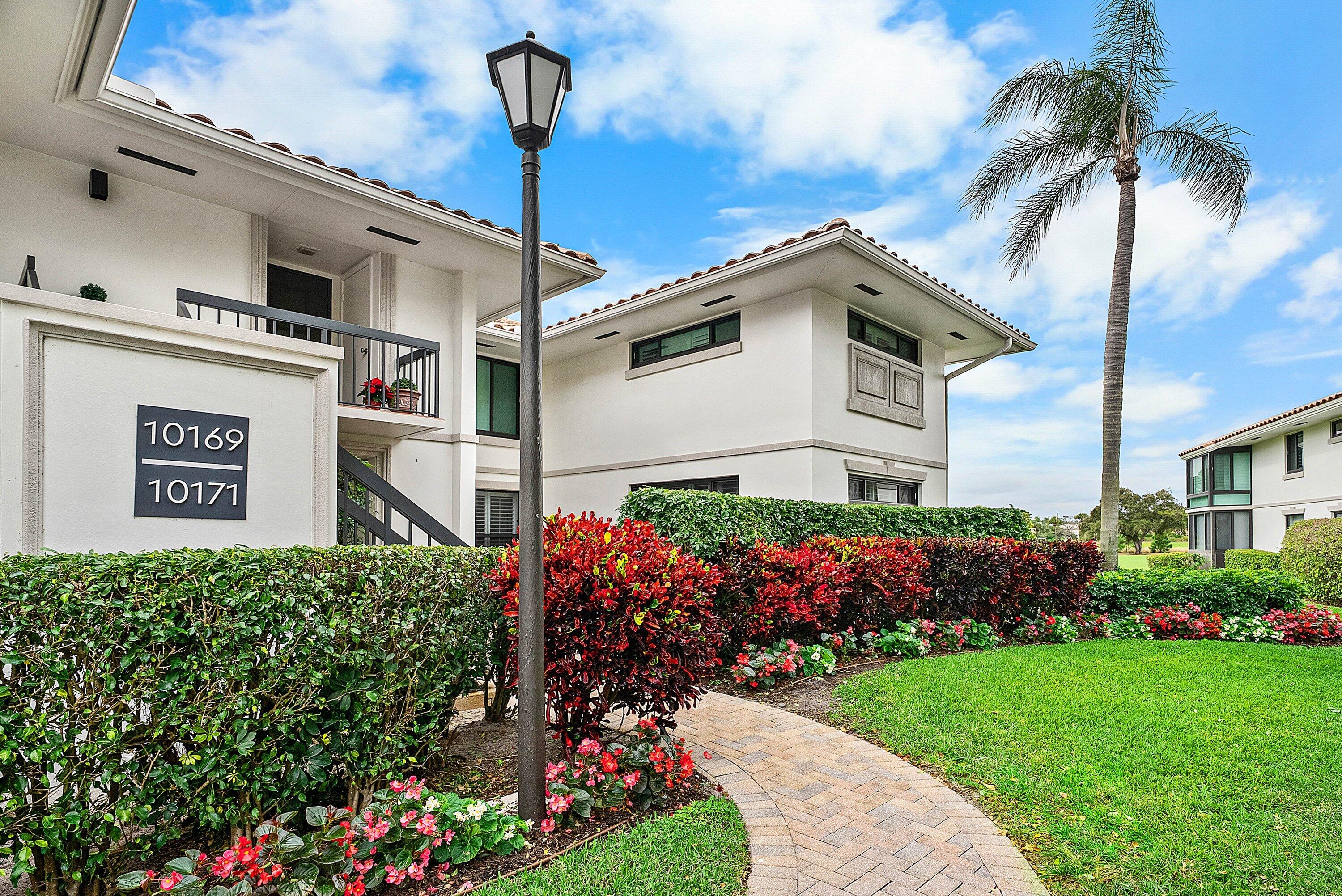 10171 Quail Covey Road, Unit HIBISCUS N Boynton Beach, FL 33436 - Photo 39 of 50 a view of a house with a small yard and potted plants