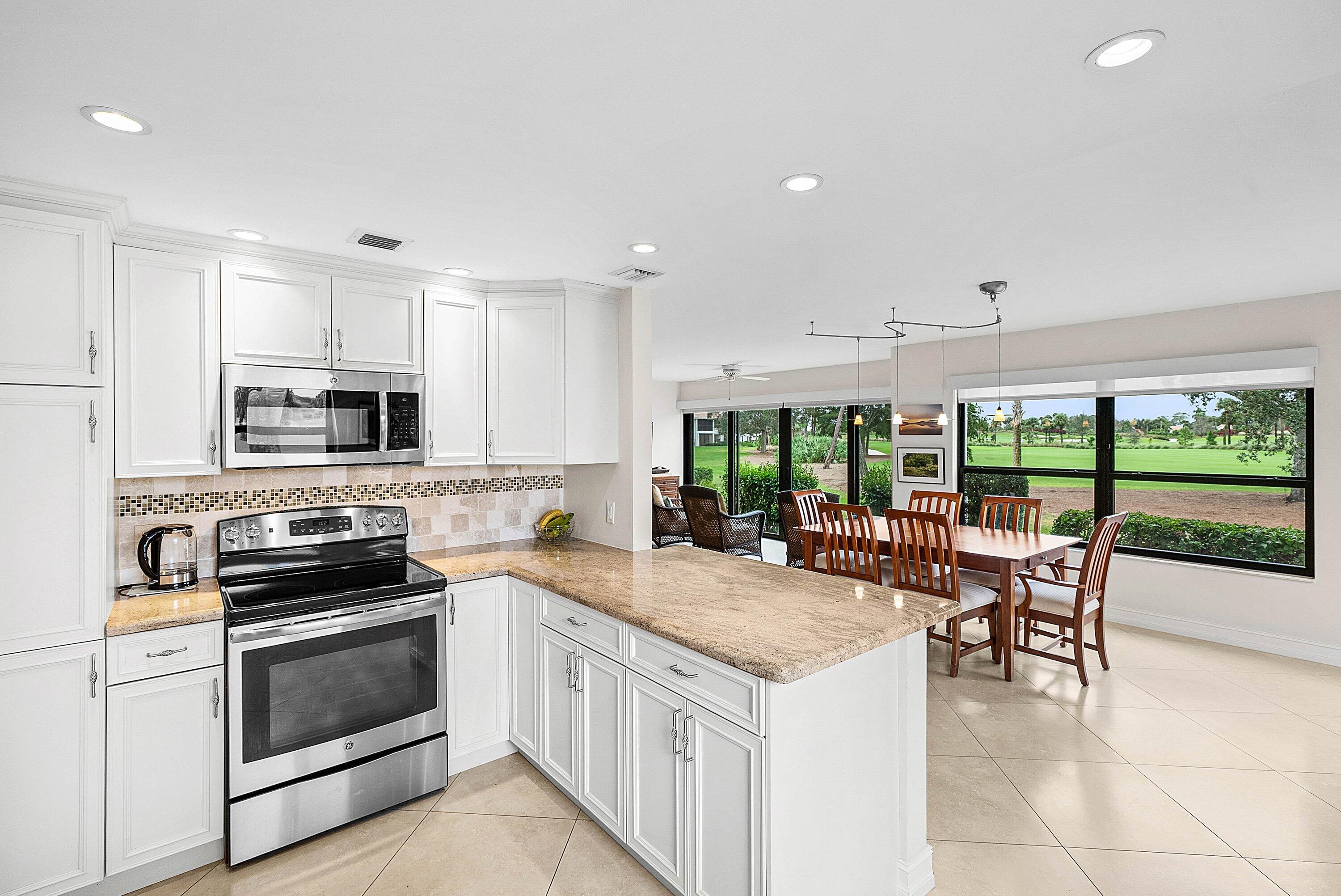 10171 Quail Covey Road, Unit HIBISCUS N Boynton Beach, FL 33436 - Photo 9 of 50 a kitchen with a stove a sink and a refrigerator