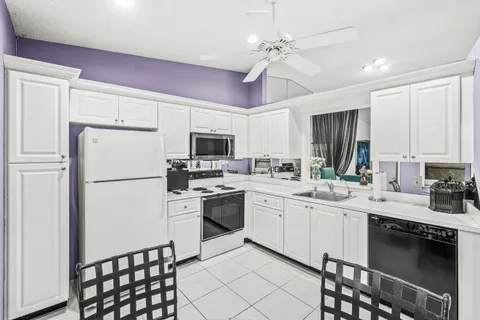 a kitchen with a sink stainless steel appliances and white cabinets