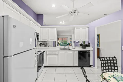 a kitchen with white cabinets and white appliances