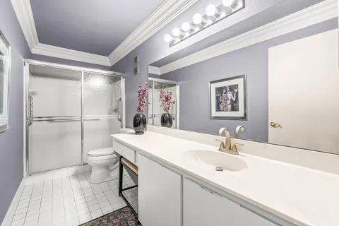 a bathroom with a sink a toilet a mirror and shower