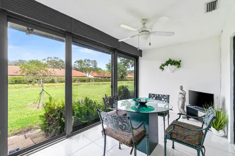 a dining room with furniture water view and a floor to ceiling window