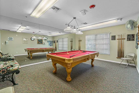 a room with furniture pool table and window