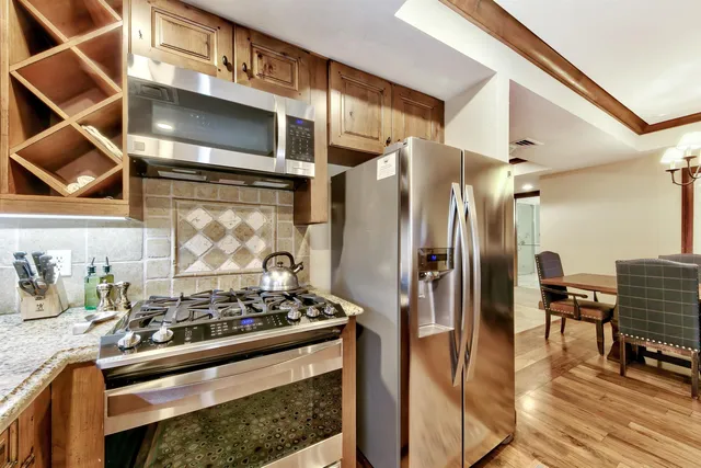 a kitchen with stainless steel appliances granite countertop a stove and a refrigerator