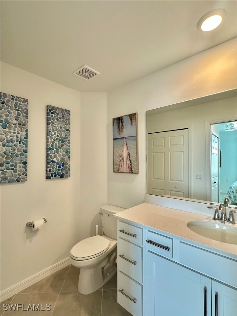 43989 Boardwalk Loop, Unit 2018 Coffeyville, KS 67337 - Photo 7 of 29 a bathroom with a sink a toilet and a mirror