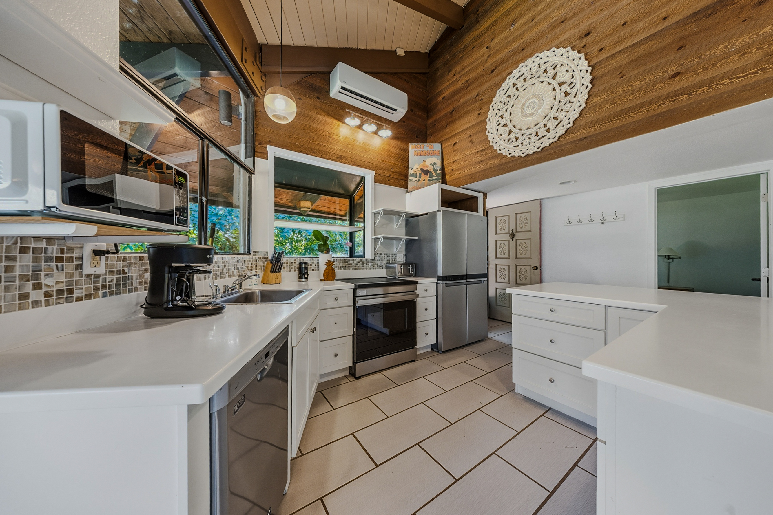 3920 Wyllie Road, Unit 7B Princeville, HI 96722 - Photo 6 of 17 a kitchen with stainless steel appliances a stove a sink and a refrigerator