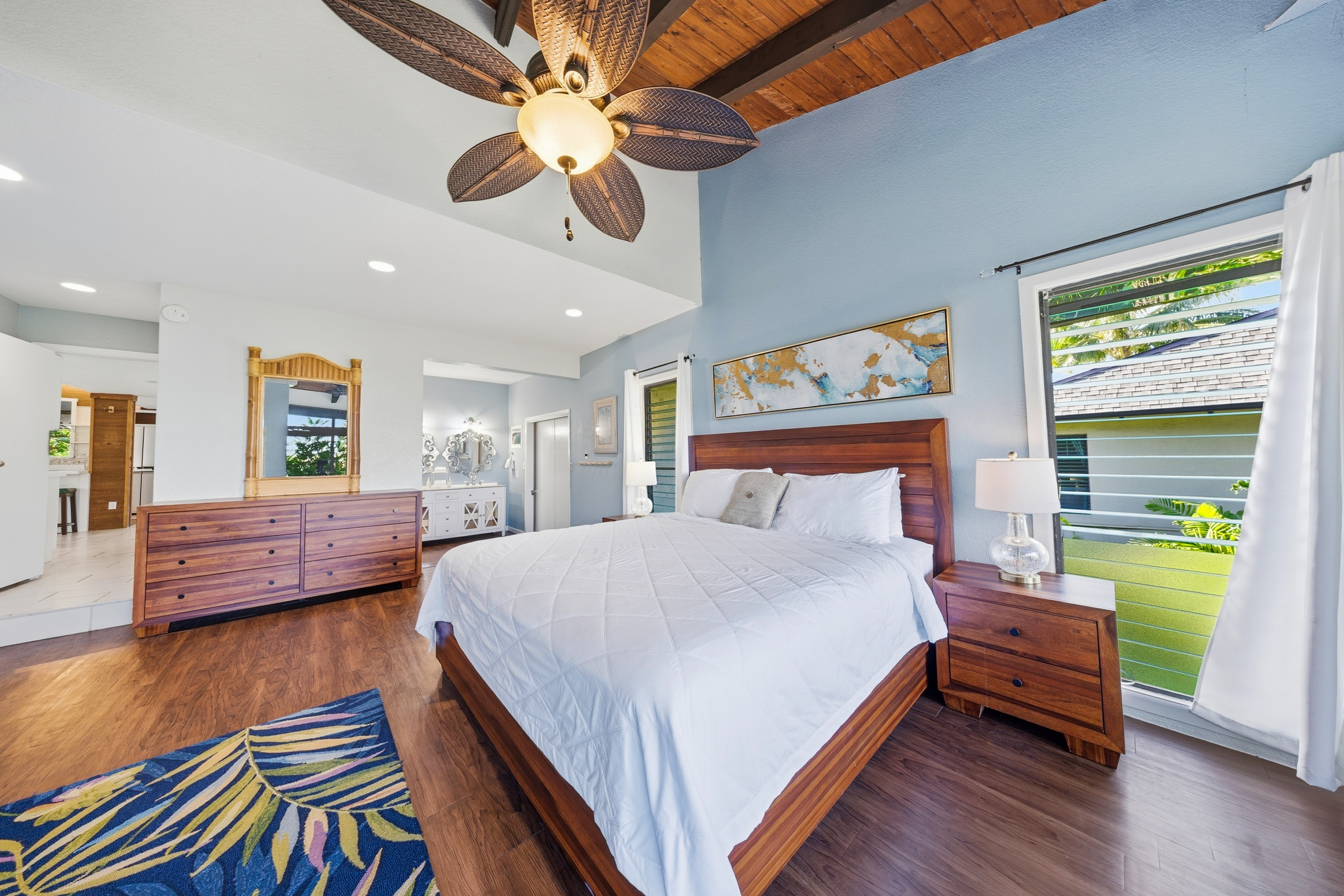 3920 Wyllie Road, Unit 7B Princeville, HI 96722 - Photo 9 of 17 a spacious bedroom with a bed and a chandelier