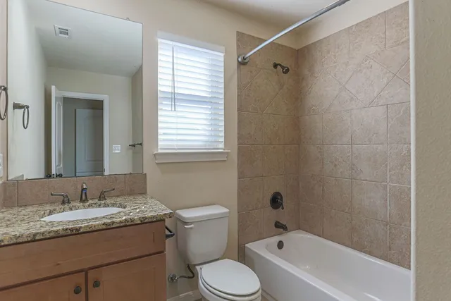 a bathroom with a granite countertop sink toilet and shower