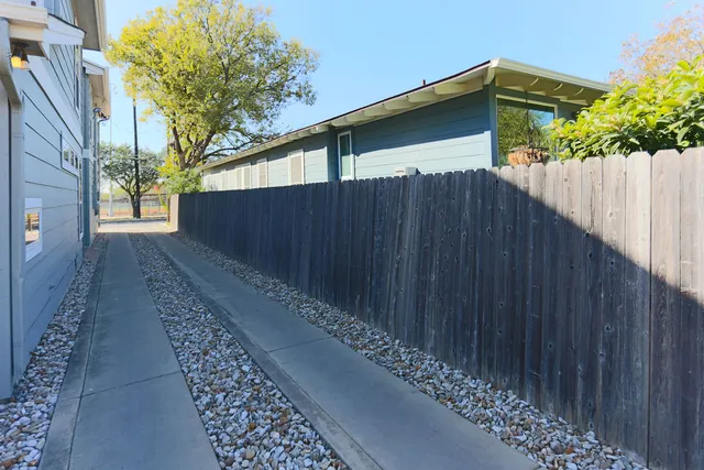 a back view of a house with a wooden fence