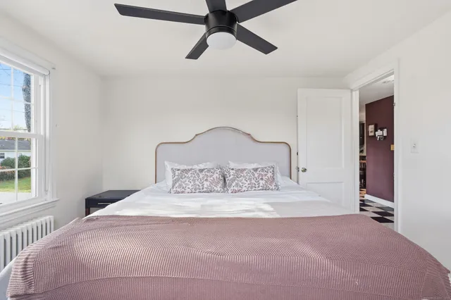 a large bed sitting in a bedroom next to a window