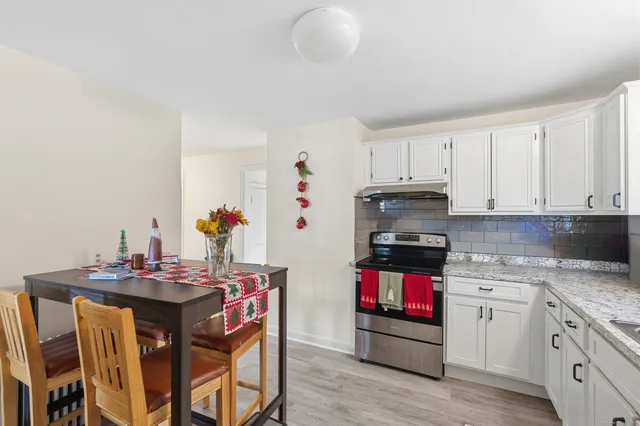 a kitchen with stainless steel appliances granite countertop a stove and cabinets