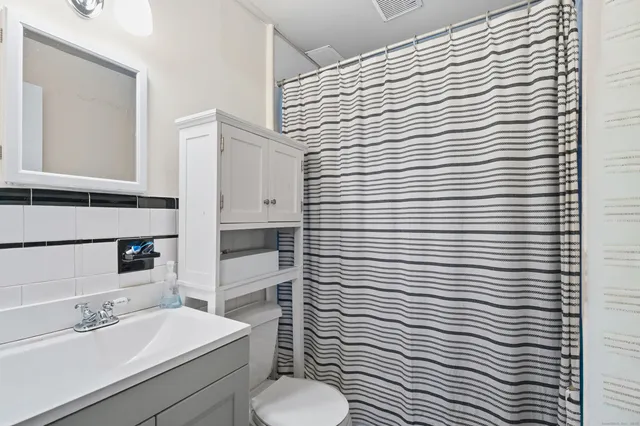 a bathroom with a toilet a sink and mirror