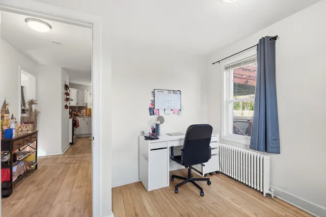 a view of a workspace with wooden floor and a window