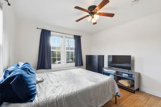 a bedroom with a bed a window and a flat screen tv