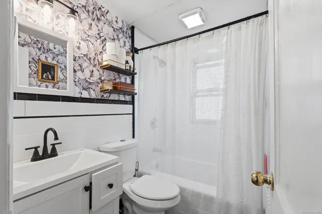a bathroom with a sink a toilet and shower curtain