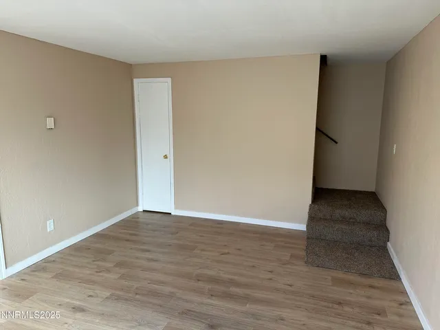 a view of an empty room and wooden floor