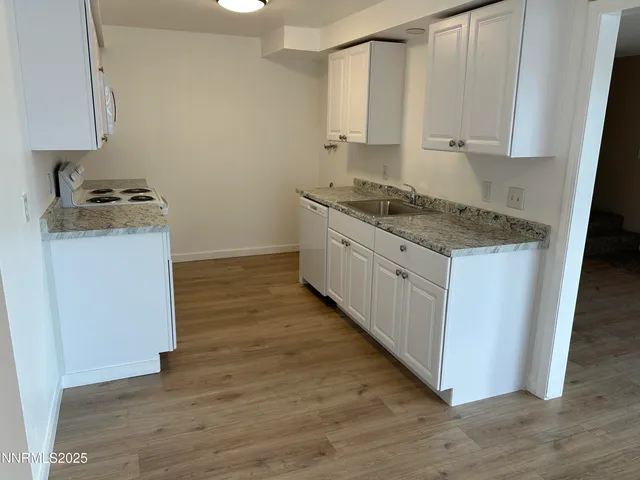 a kitchen with wooden floor and a stove top oven