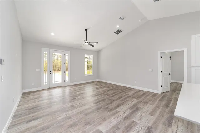 a view of a livingroom with a ceiling fan & hardwood floor