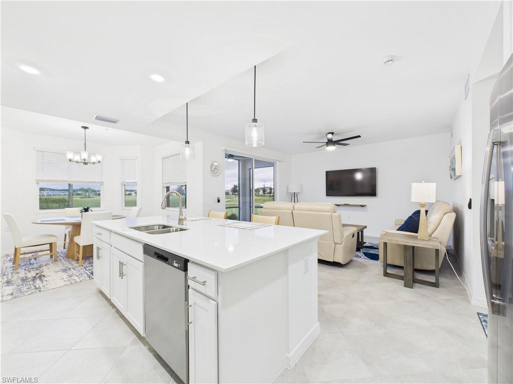 5527 Double Eagle Circle, Unit 3817 Ave Maria, FL 34142 - Photo 6 of 26 a large white kitchen with a sink and living room view