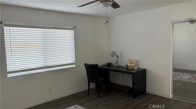 a view of a workspace with furniture and a window