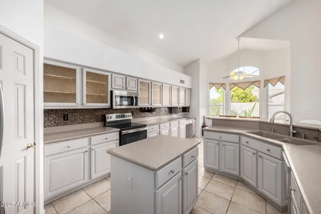 a view of a big room with chandelier fan and windows