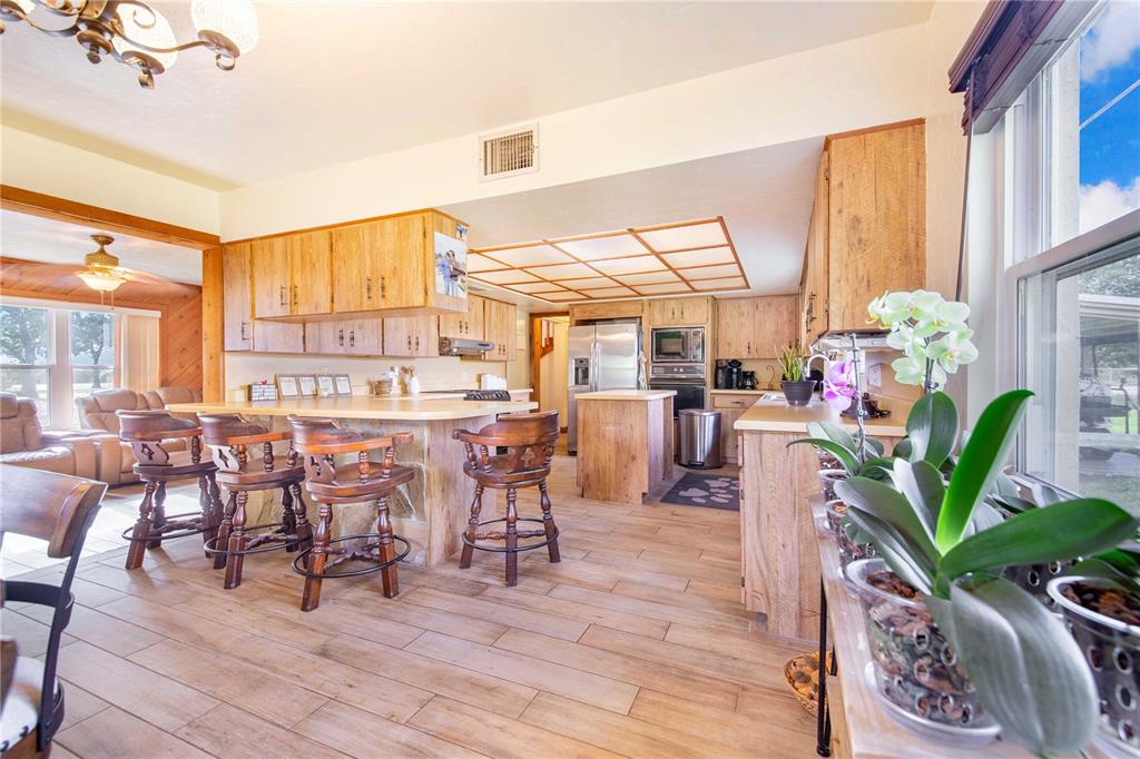 1646 Tyner Road Haines City, FL 33844 - Photo 16 of 64 a living room filled with furniture hardwood floor and a kitchen view