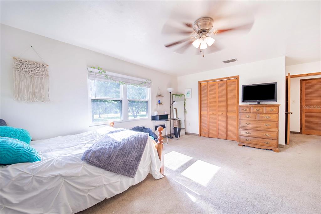 1646 Tyner Road Haines City, FL 33844 - Photo 26 of 64 a spacious bedroom with a bed and a chandelier