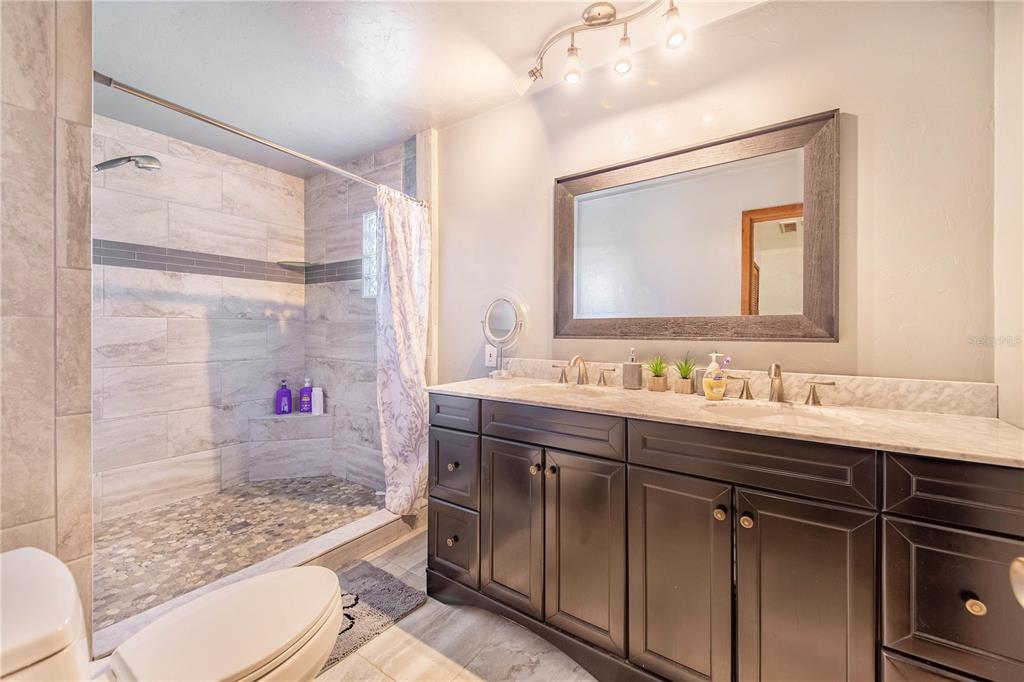 1646 Tyner Road Haines City, FL 33844 - Photo 29 of 64 a bathroom with a shower sink vanity mirror and toilet