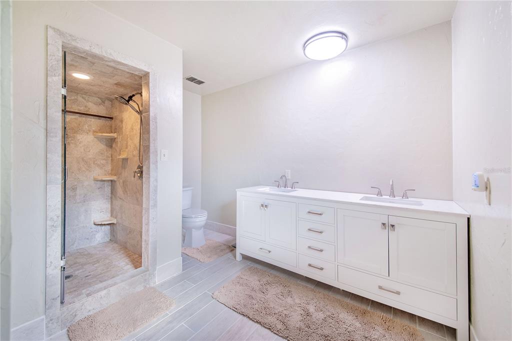 1646 Tyner Road Haines City, FL 33844 - Photo 35 of 64 a spacious bathroom with a double vanity sink a mirror and a shower