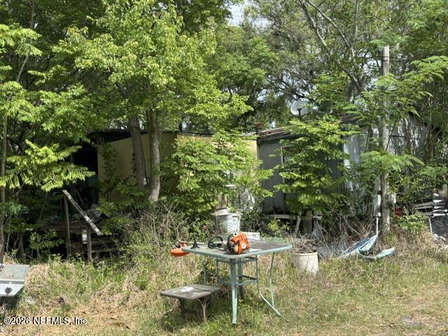 85336 Crews Road North Fernandina Beach, FL 32034 - Photo 4 of 8 a backyard with table and chairs and potted plants