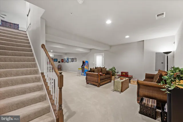 a living room with furniture and stairs