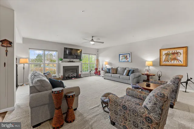 a living room with furniture fireplace and a large window