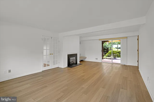 a view of empty room with wooden floor and fireplace