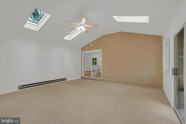 a view of an empty room with a chandelier fan