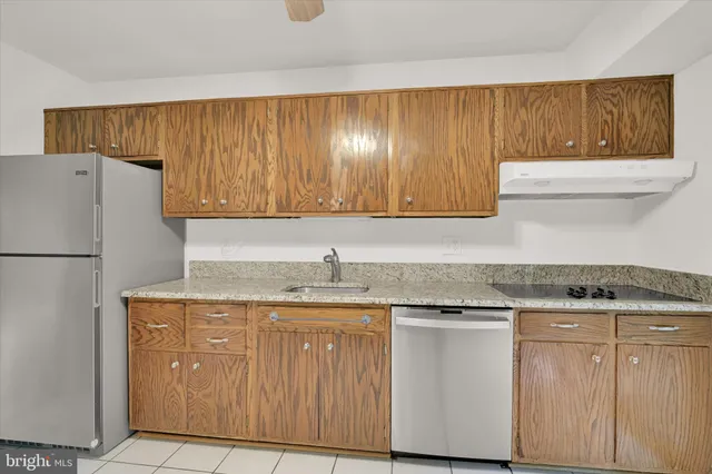 a kitchen with granite countertop cabinets stainless steel appliances and a counter space