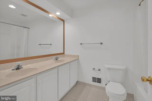 a bathroom with a granite countertop sink a toilet and a mirror