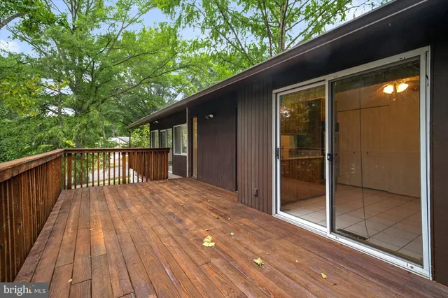 a view of backyard with wooden floor and wooden fence