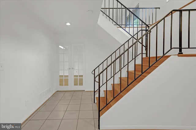 a view of staircase with wooden floor and white walls