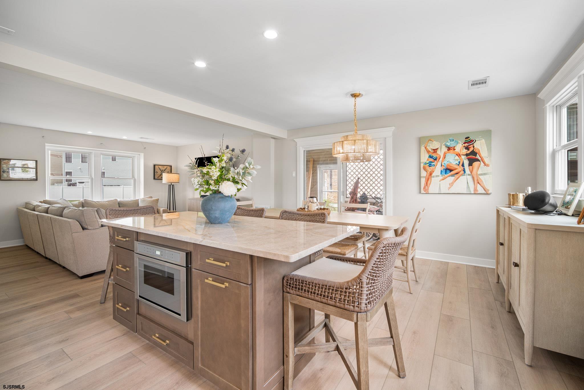 a dining hall with stainless steel appliances granite countertop a dining table and chairs