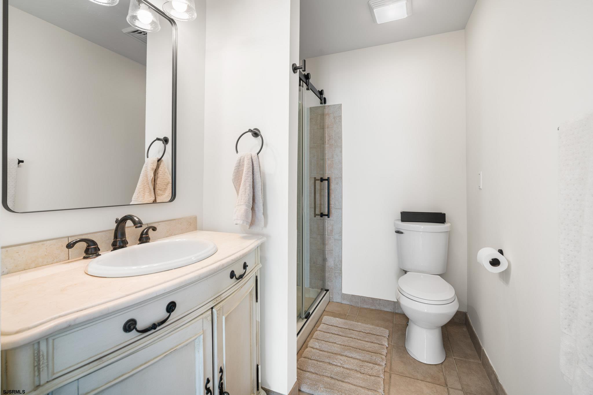 5217 Seaspray Road Brigantine, NJ 08203 - Photo 17 of 35 a bathroom with a sink a toilet and a mirror