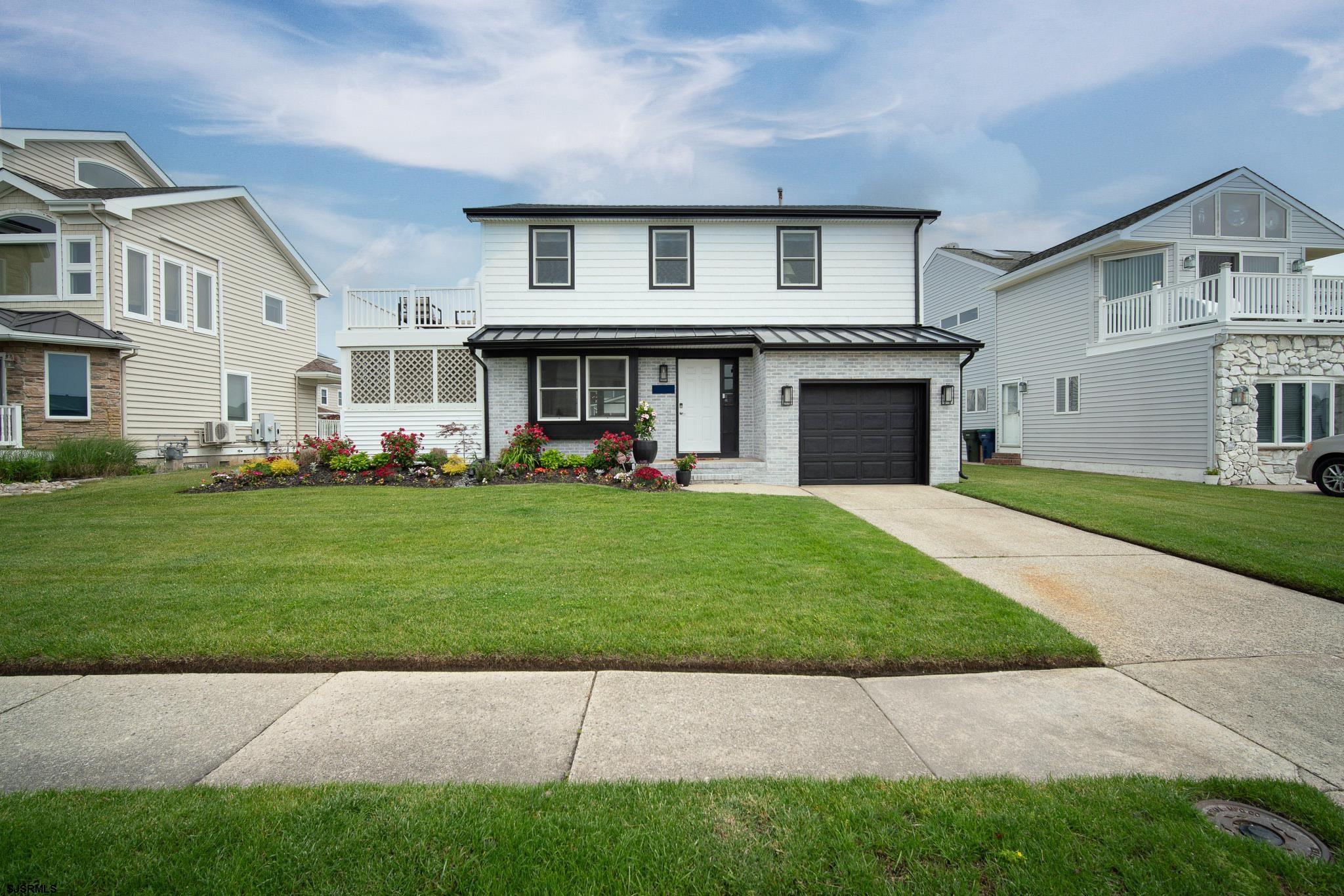 5217 Seaspray Road Brigantine, NJ 08203 - Photo 24 of 35 a view of a white house in front of a big yard with plants and large trees